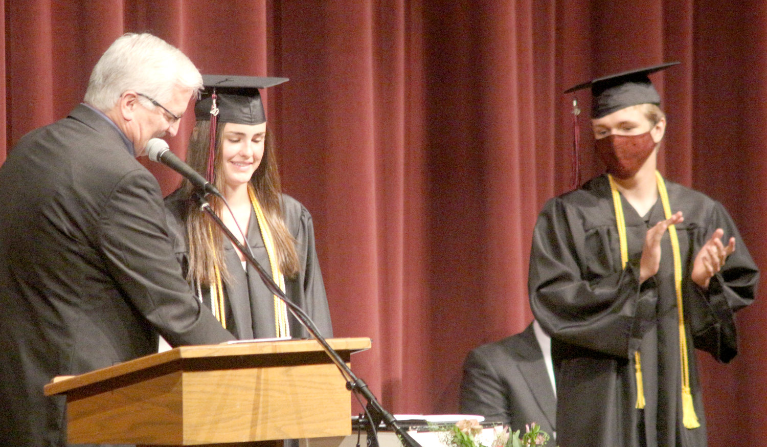 Hillcrest Academy Principal Dwight Gingerich (left) congratulates salutatorian Mia Graber and valedictorian Jesse Slater during Sunday’s commencement ceremony in Celebration Hall.